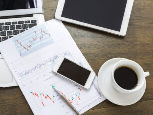 Laptop, tablet , smartphone and coffee cup with financial docume